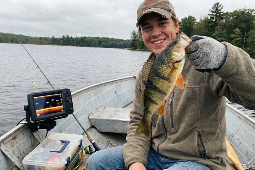 Angler beim Vertikalangeln auf Barsch vom Boot mit Echolot und Baitcaster-Rute