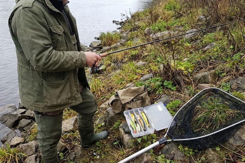 Angler beim Spinnfischen am Flussufer mit Hechtmontage